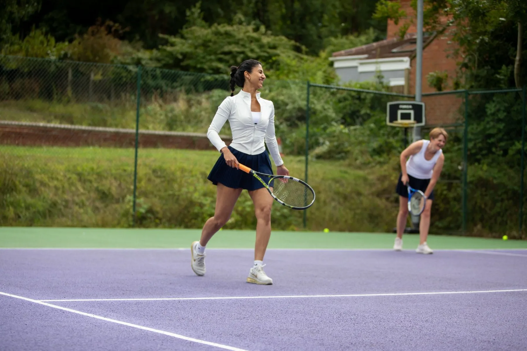 Adult tennis player moving across the court with a racket
