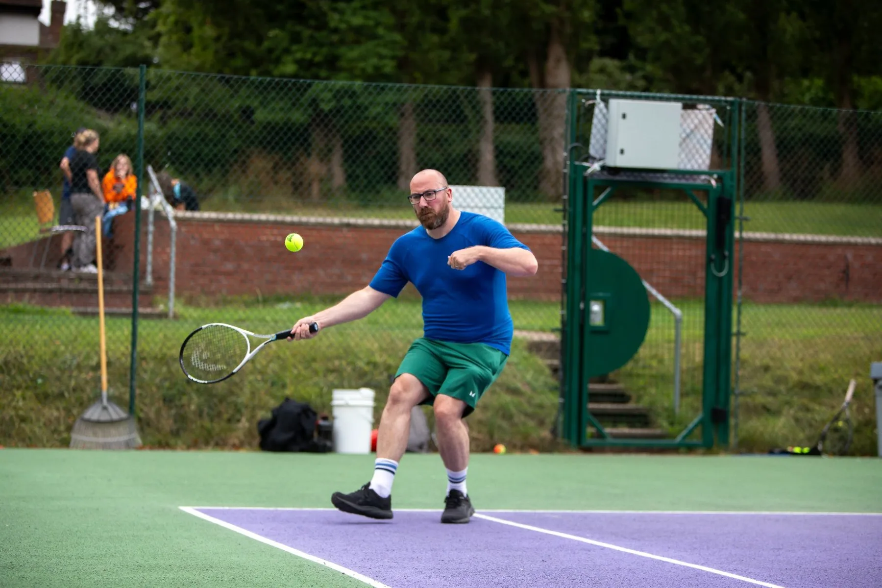 Adult tennis player reaching for a ball during a rally
