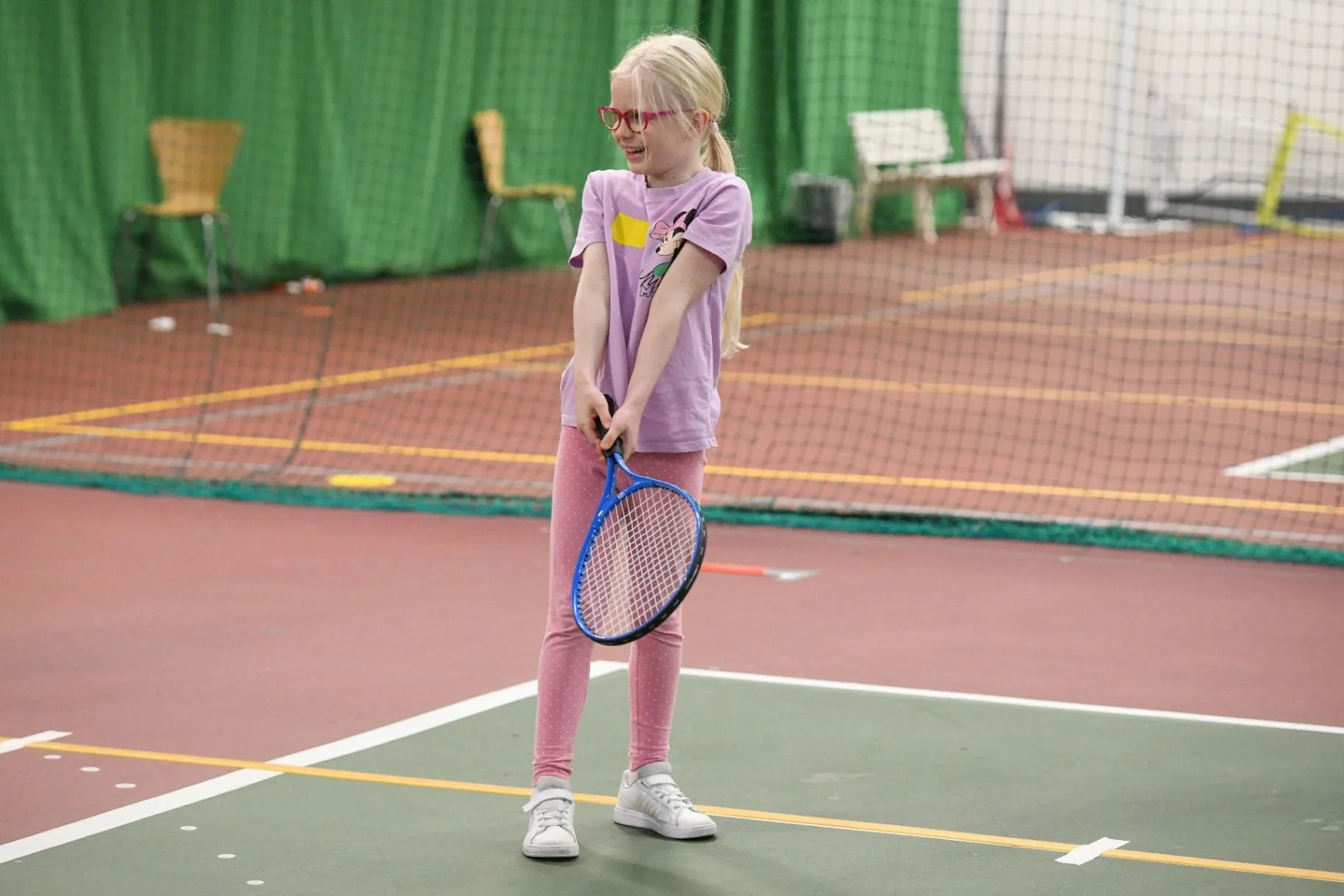Young tennis player holding a racket on an indoor court