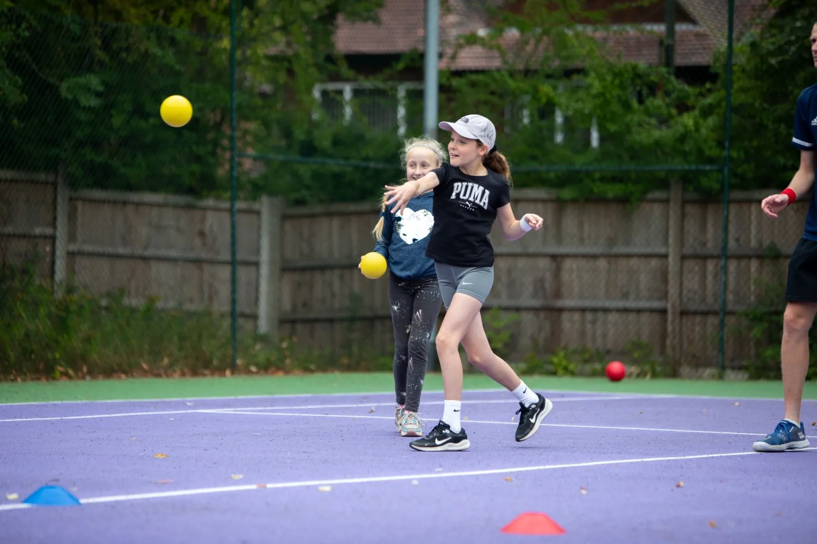Young player practising with a yellow ball on an outdoor court