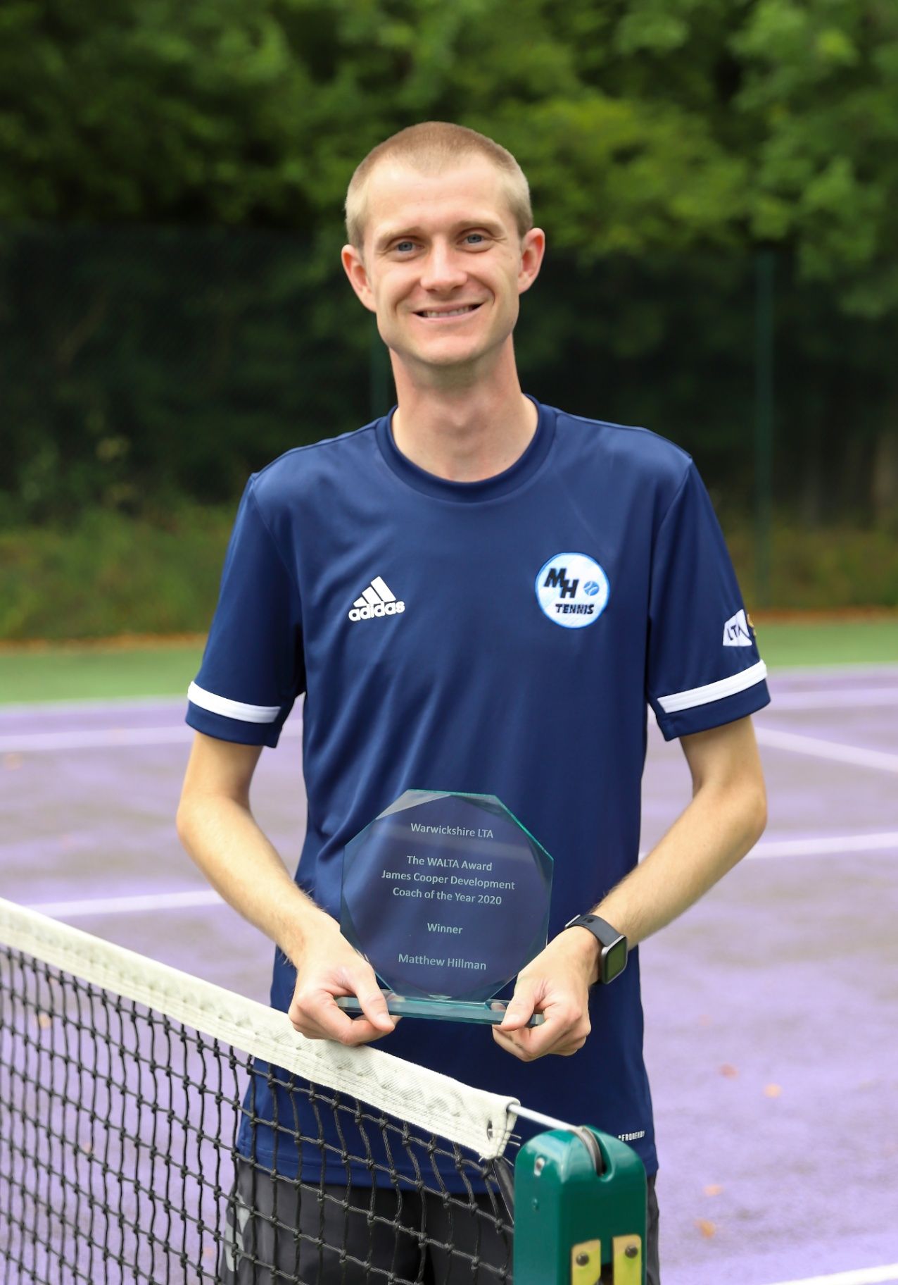 Matthew Hillman, MH Tennis Head Coach, holding his Coach Development Coach of the Year 2020 award