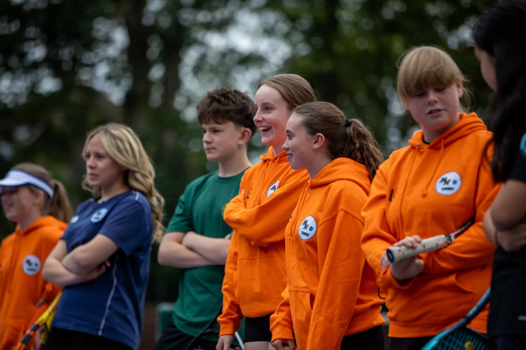 Group of MH Tennis Young Leaders standing together with tennis rackets
