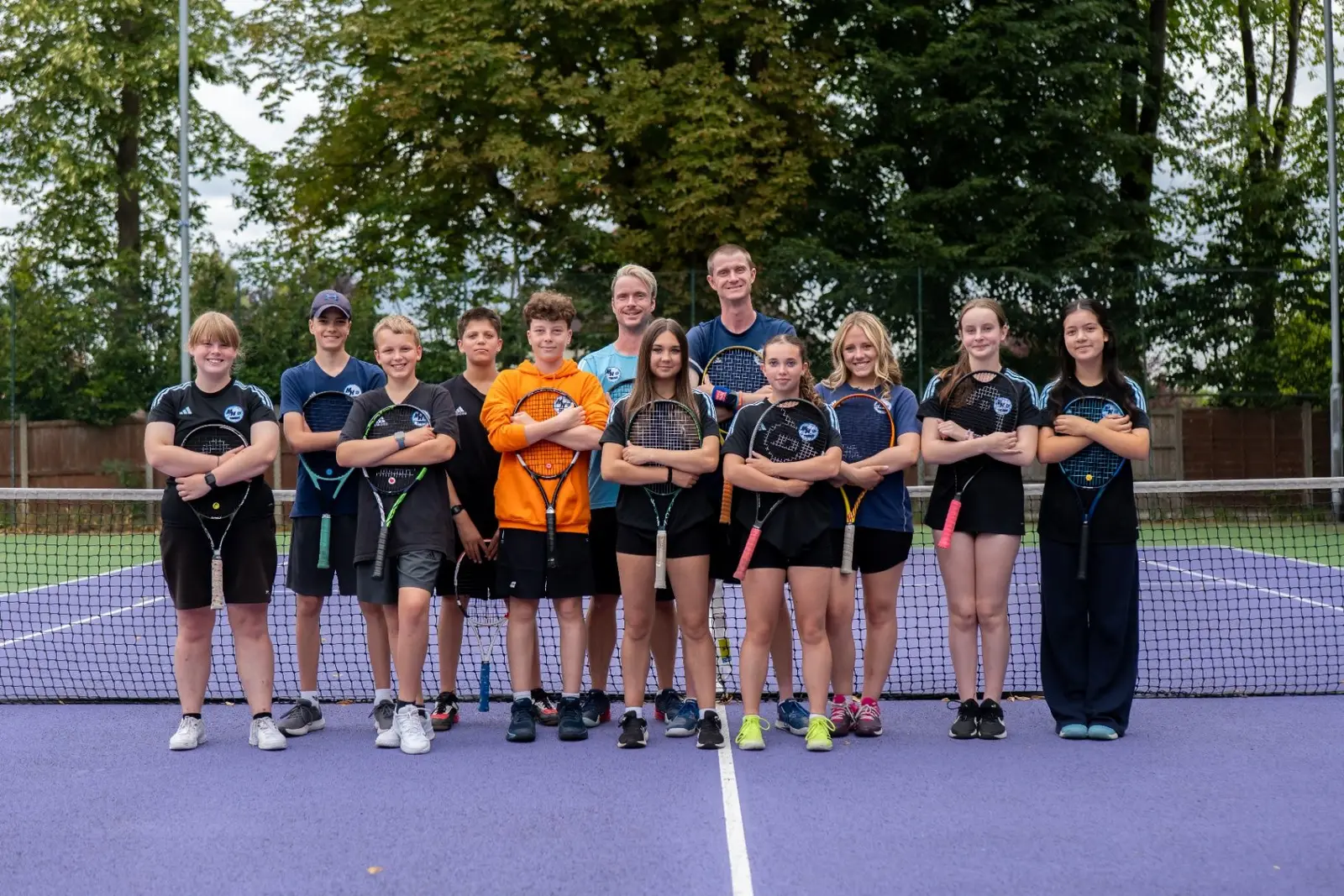 MH Tennis Young Leaders and coaches standing together on a tennis court