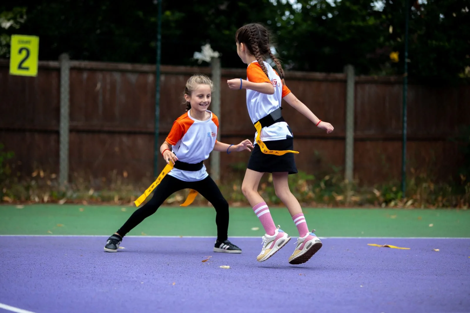 Two young players moving across the court during a game
